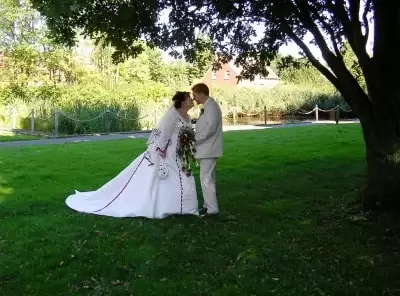 Hochzeitspaar küsst sich auf Rasen
